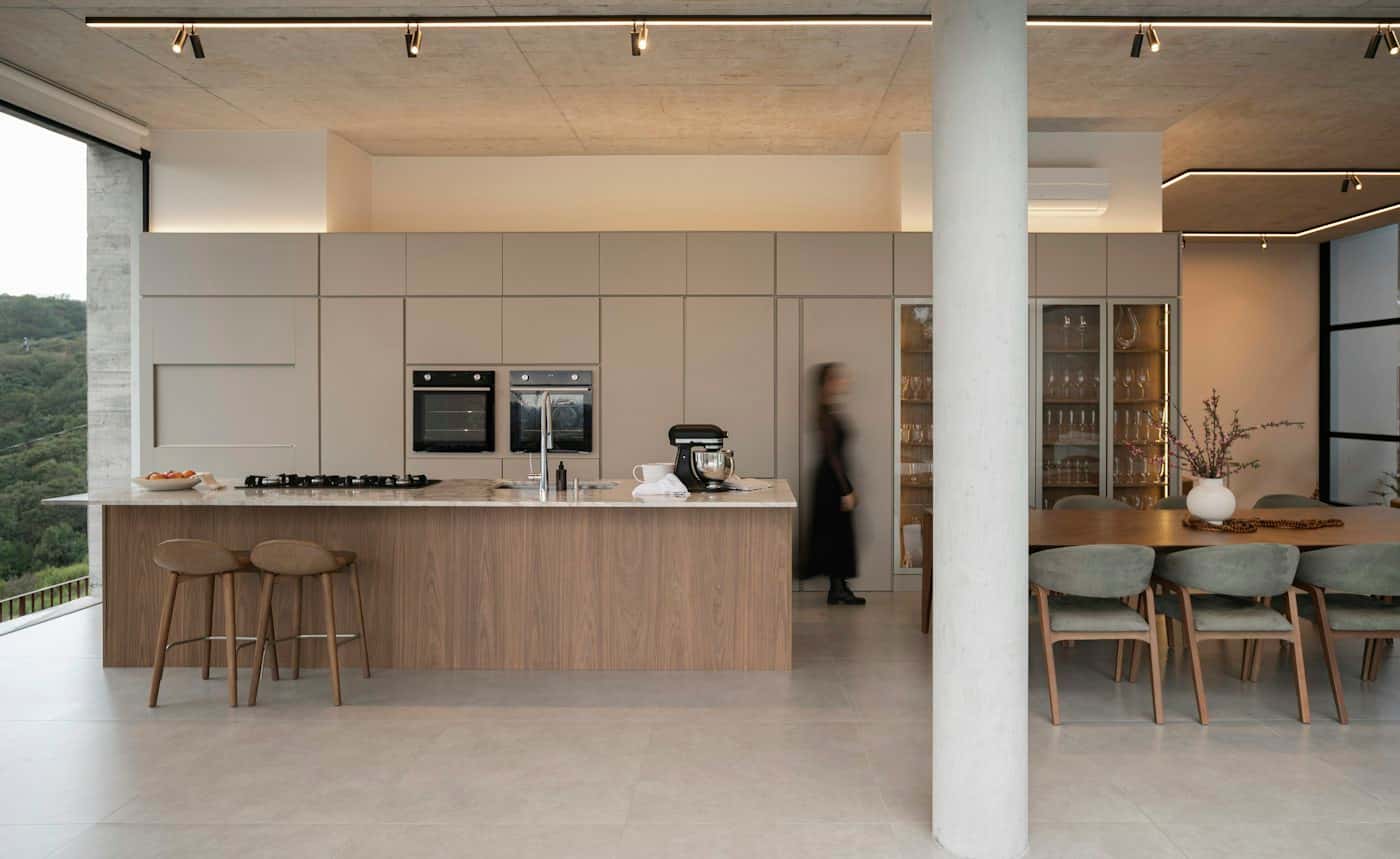 Cocina integrada con isla de madera y ventanales